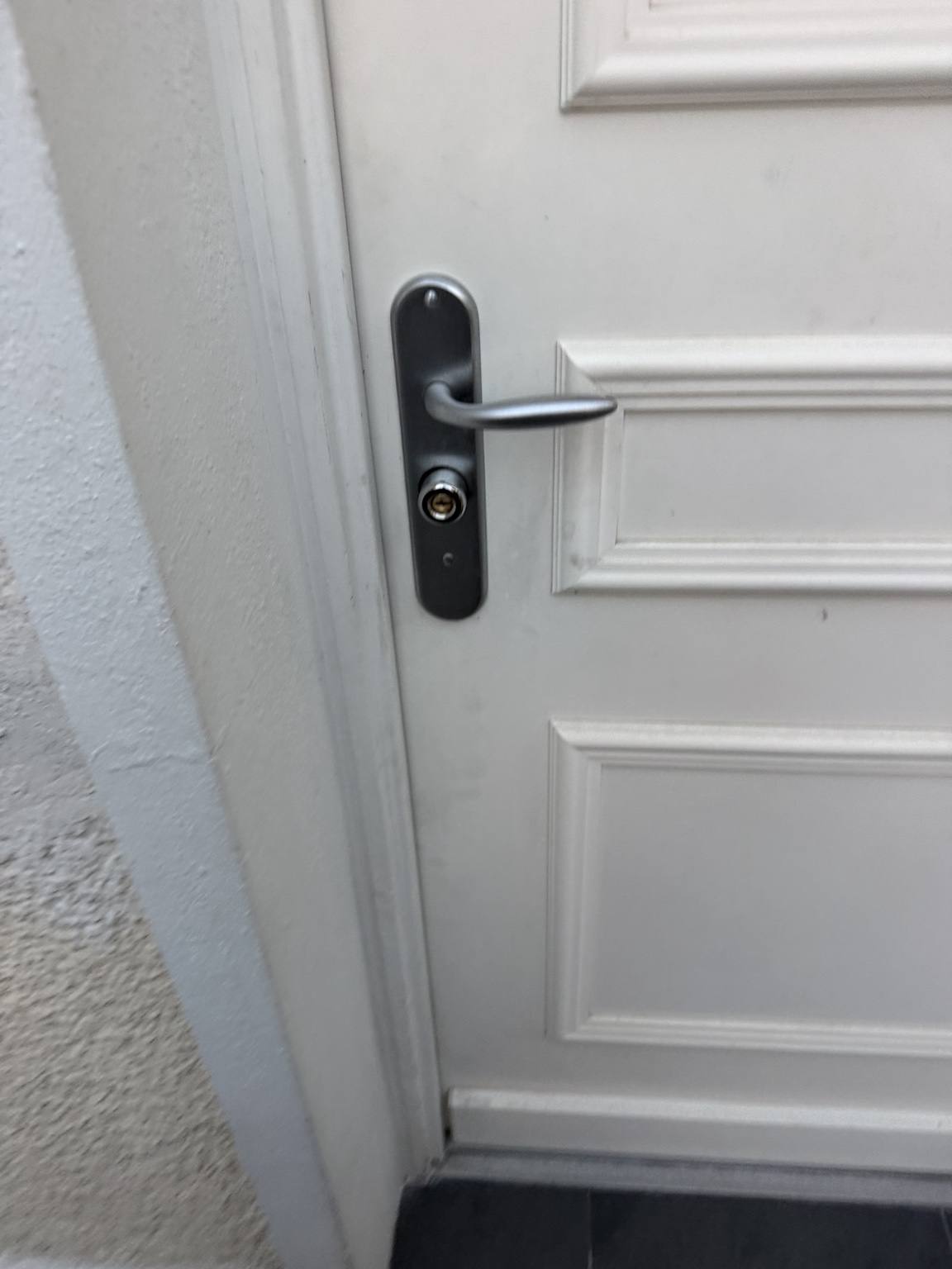 Pose poignée & cylindre sur porte d'entrée blanche — Torcy (Seine-et-Marne) · Atelier Brochant